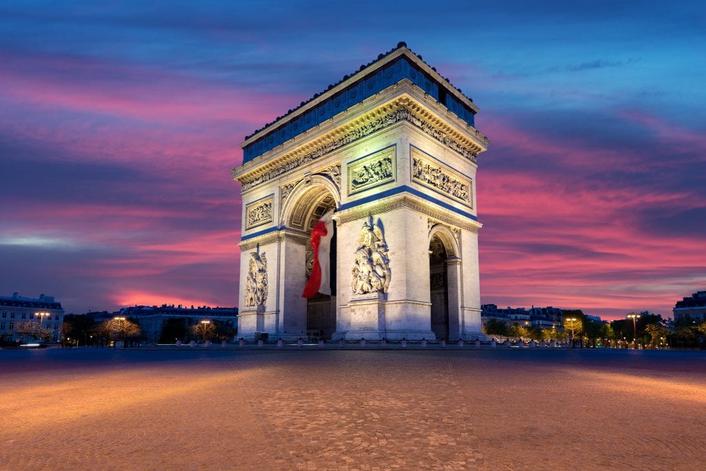 תרגום מעברית לצרפתית בתמונה: שער הניצחון בפריז צרפת על רקע השקיעה