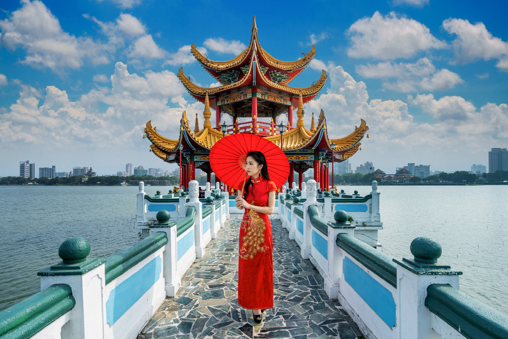 תרגום מסמכים לסינית בתמונה: אישה אוחזת מטריה אדומה עומדת על גשר 