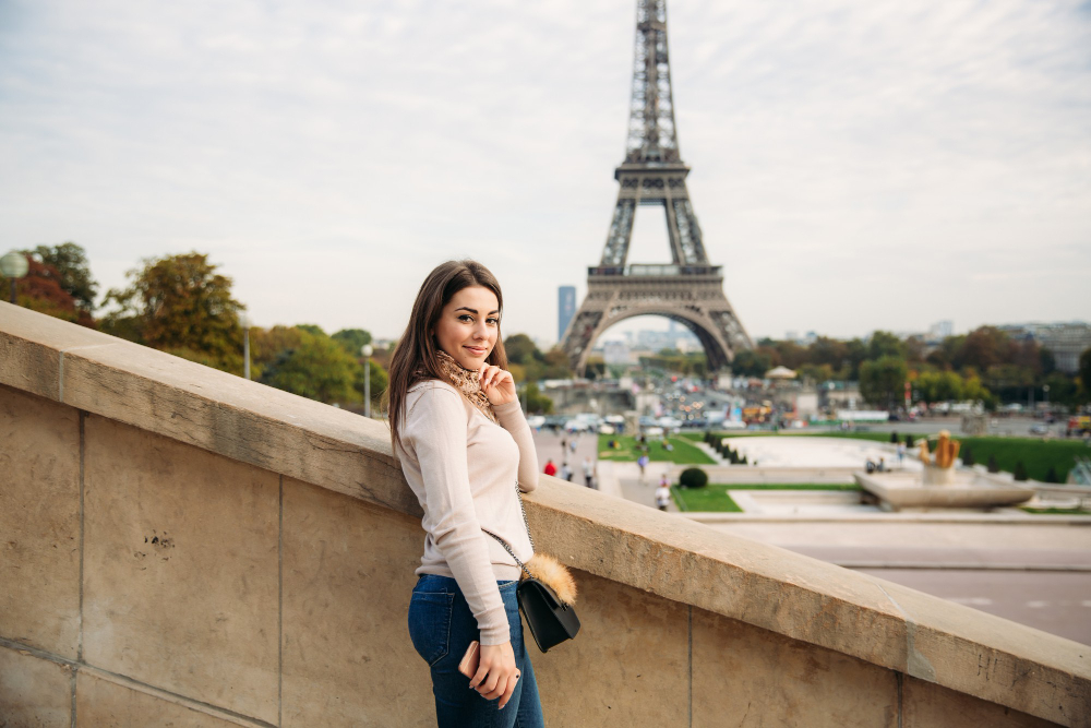 תרגום מסמכים לצרפתית בתמונה אישה צעירה על רקע מגדל אייפל צרפת פריז