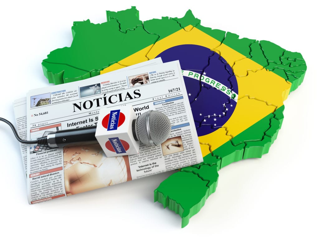תרגום מסמכים מפורטוגזית לעברית בתמונה: מפת ברזיל בצבעי הדגל ירוק צהוב כחול ועליו עיתון 