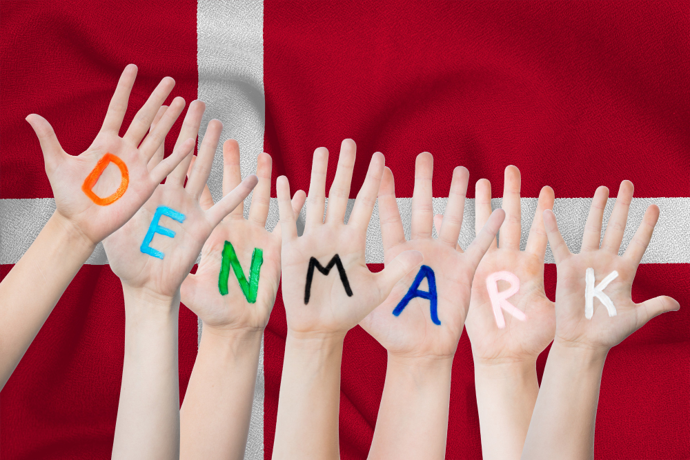 תרגום מסמכים לדנית בתמונה גח רקע דגל דנמרק חמש כפות ידיים עליהם אותיות באנגלית דנמרק 