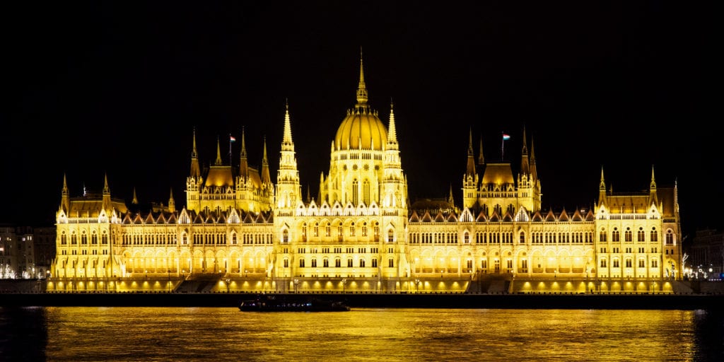 תרגום מסמכים להונגרית מעברית או אנגלית בתמונה הפרלמנט ההונגרי מואר על נהר הדנובה בבודפשט.