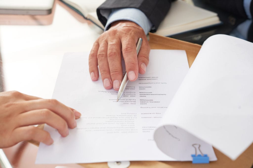 people examining business resume SXU6YYJ scaled