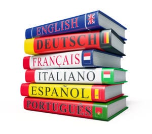 תרגום מסמכים לשפות בתמונה: ערמת מילונים בשפות אנגלית, ספרדית, פורטוגזית, צרפתית 